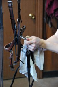 Cleaning the bit on an English horse bridle