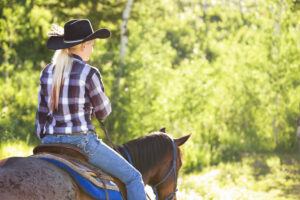 a woman riding a roan horse in western tack