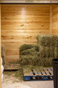 hay storage for hay bales on wooden pallets in a horse barn