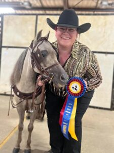Katie Miller and her Miniature Horse winning a champion ribbon